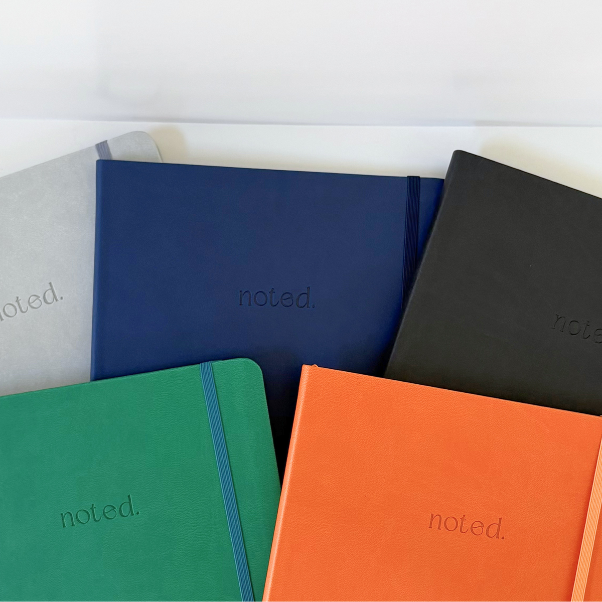 Five colorful productivity notebooks with 'noted.' branding on a white background