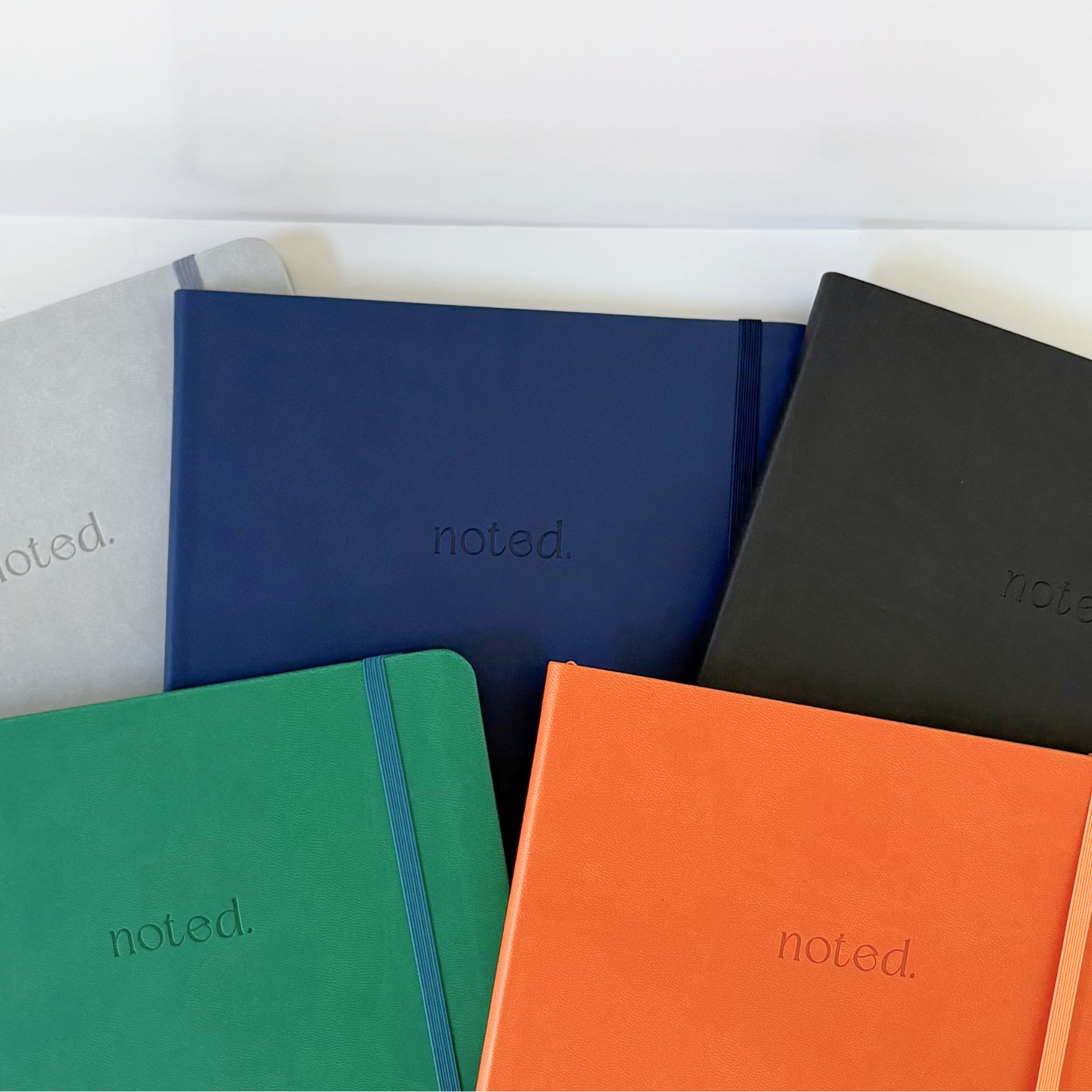 Five colorful productivity notebooks with 'noted.' branding on a white background